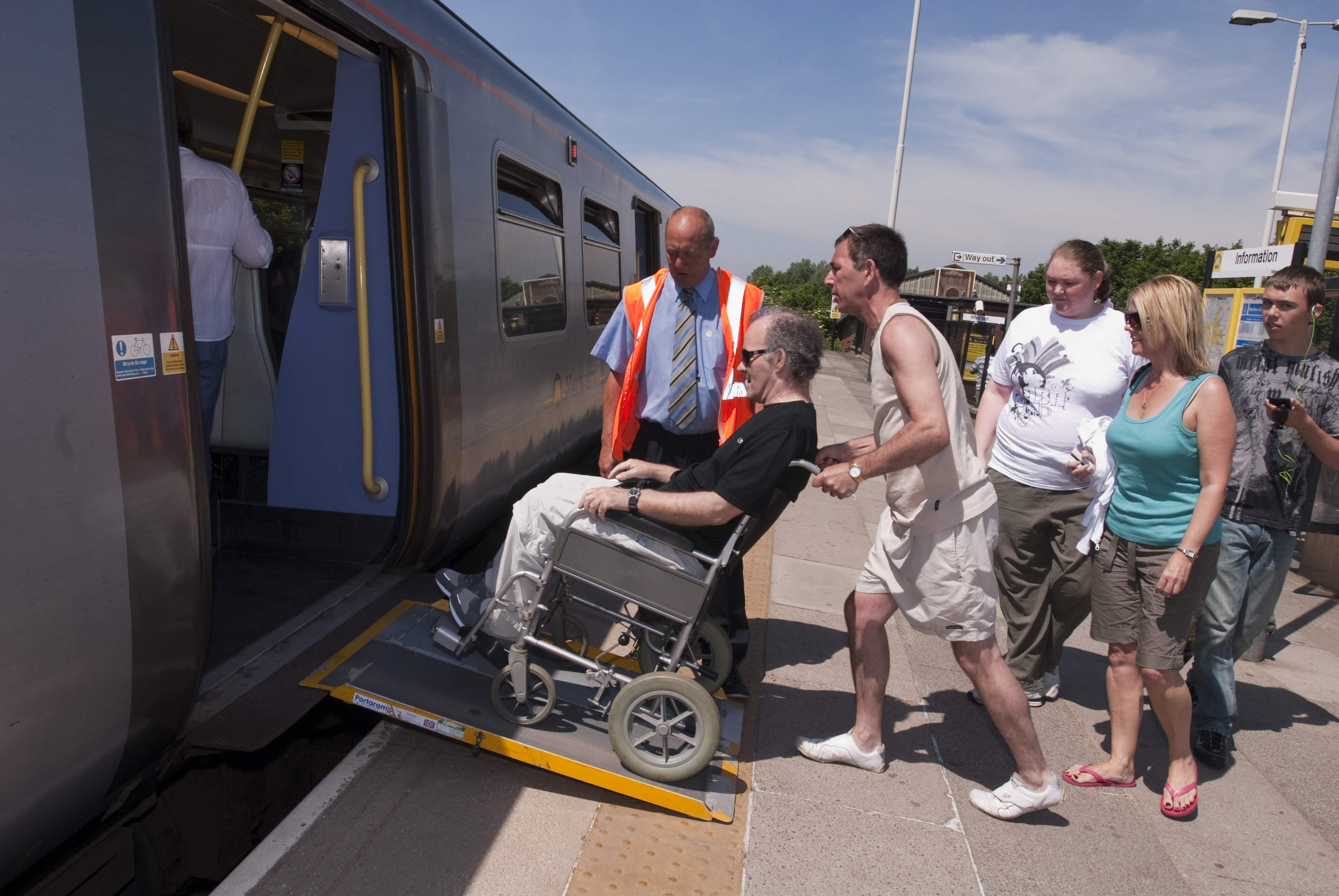 Disabled passenger being helped onto a train.