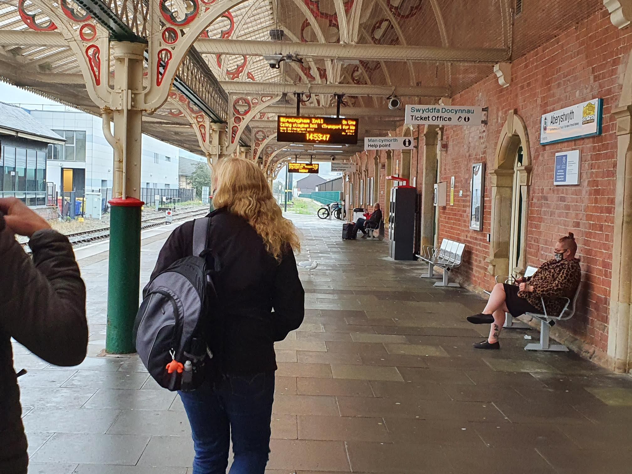 passenger on platform at Aberystwyth looking at departure board