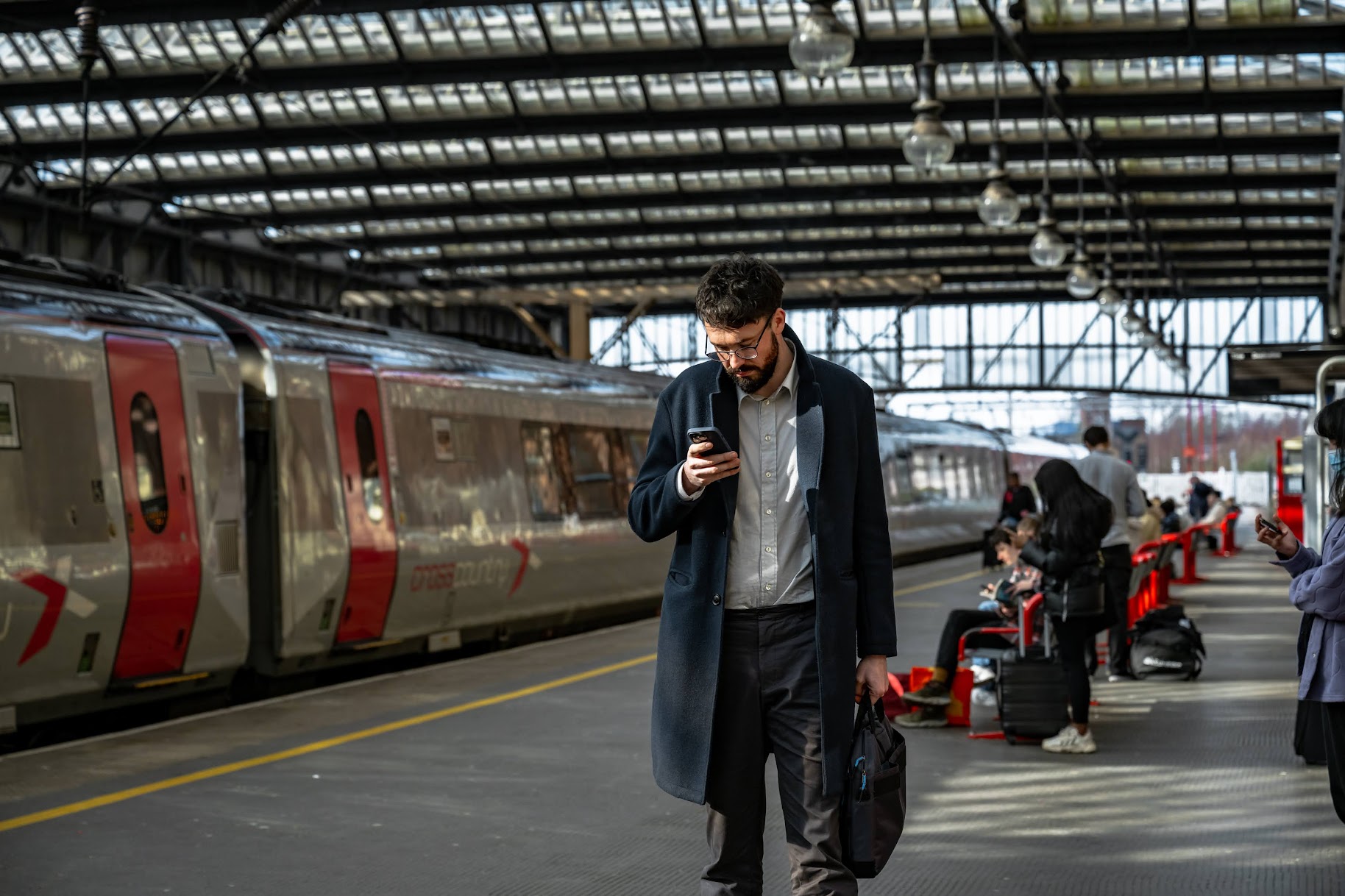 Man checks phone on train platform