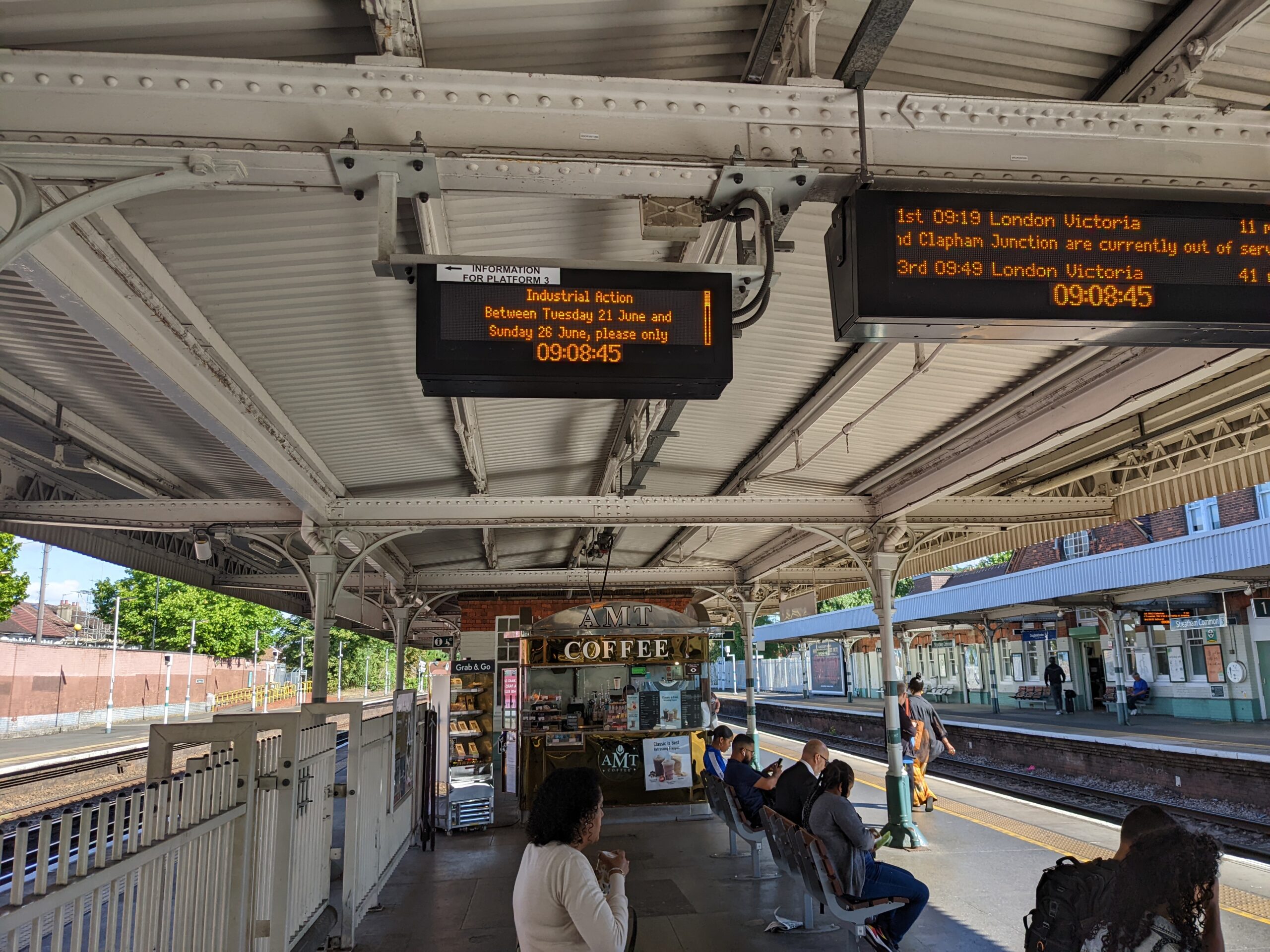 Rail station platform with overhead sign warning of industrial action