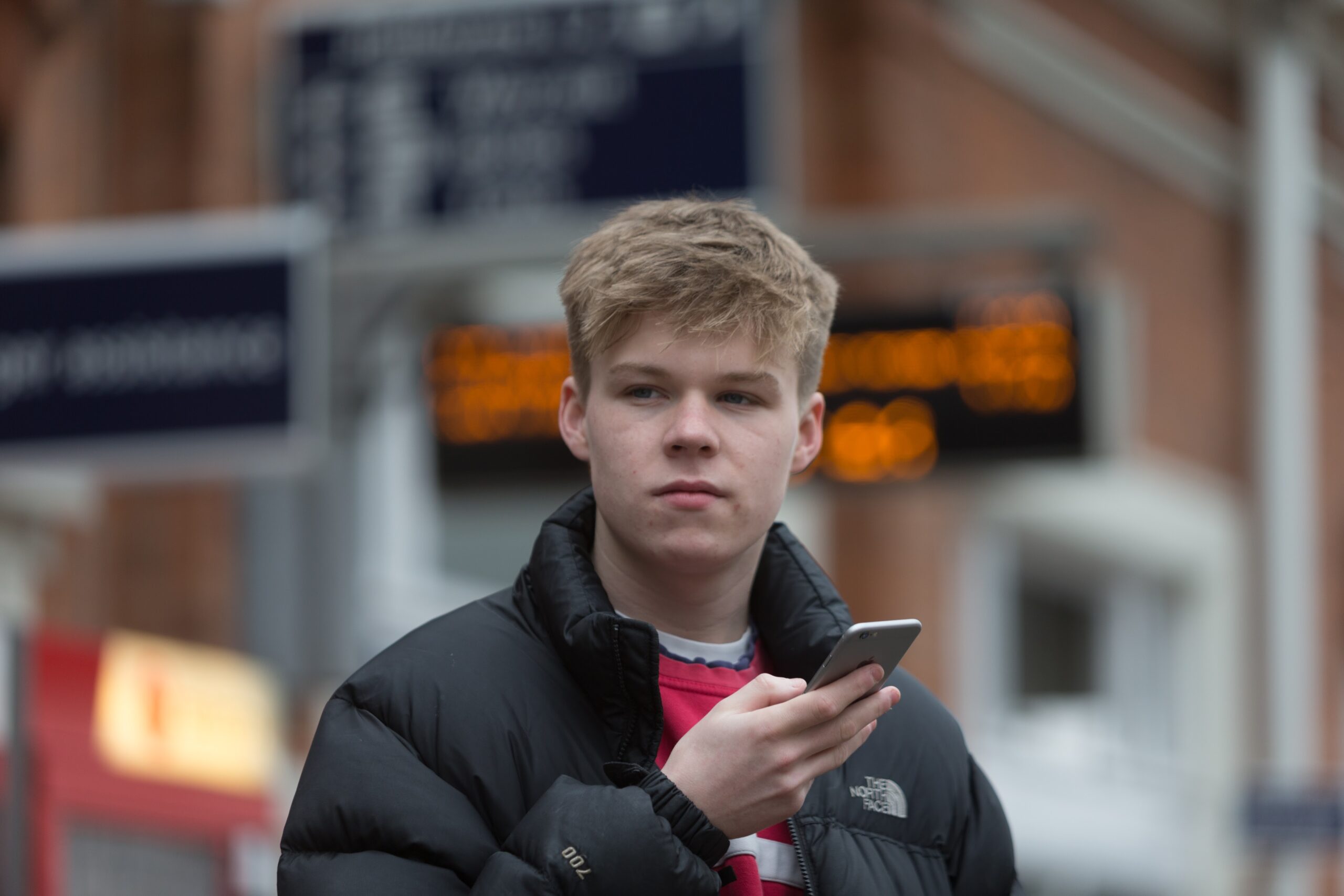Passenger looking at mobile phone at train station.