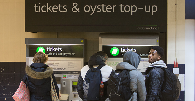 Passengers at a ticket machine in London.
